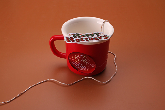 A red coffee mug customized with Merry Christmas holiday vinyl stickers.