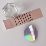 A rectangular pink label and a circular holographic sticker.