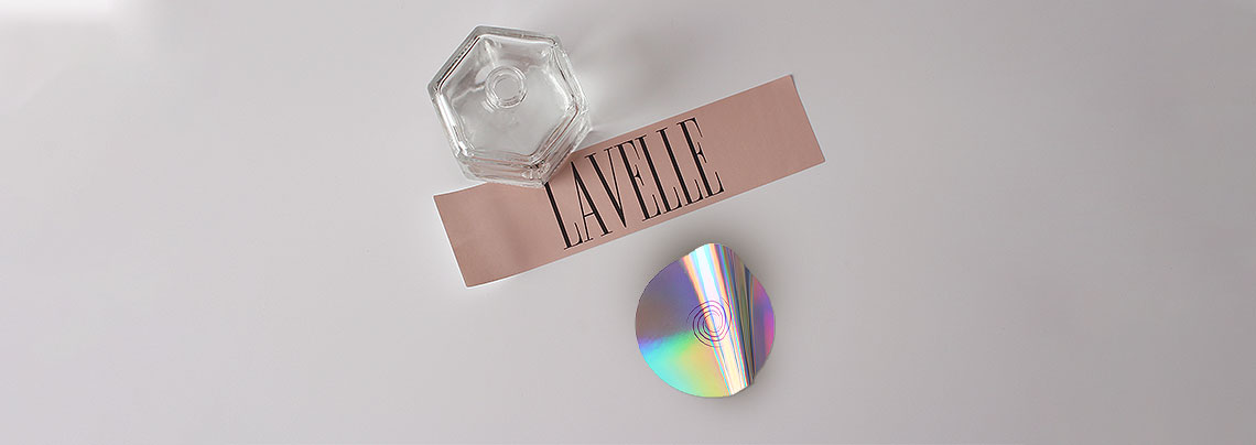A rectangular pink label and a circular holographic sticker.