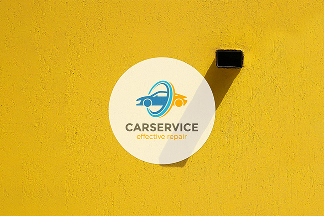 A car service logo sticker on a yellow wall, perfect for comparing vinyl or paper stickers.