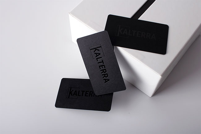 Three sleek black business cards displaying the brand name "KALTERRA" in a bold, glossy spot-UV font.