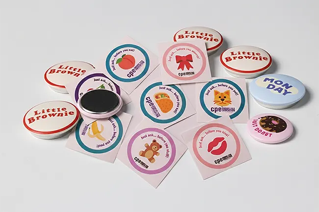A collection of colorful square stickers and round magnets.
