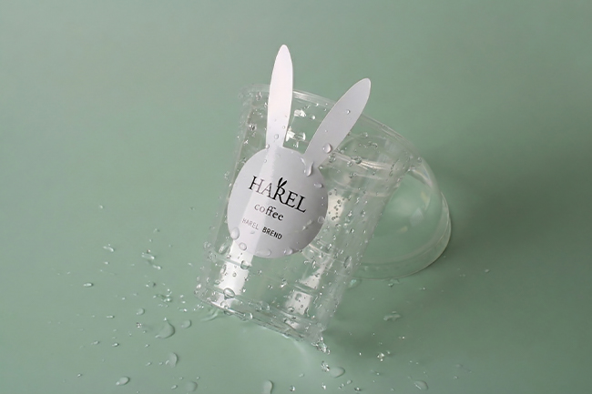 White bunny sticker on a wet plastic cup, showing light moisture exposure relevant to waterproof vs water-resistant choices.
