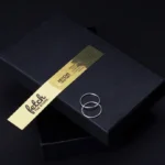 Gold foil brand sticker on a black jewelry box.