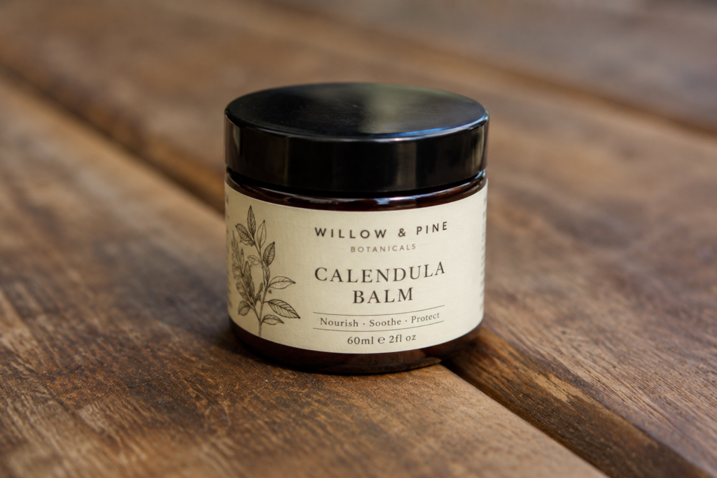 Close-up of a matte textured paper brand label on a dark amber cosmetic jar.