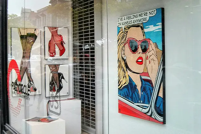 Pop Art prints displayed in a gallery shop window, showing Lichtenstein-style illustration and halftone dot textures