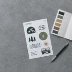 Sticker sheet and color palette guide on a grey desk.